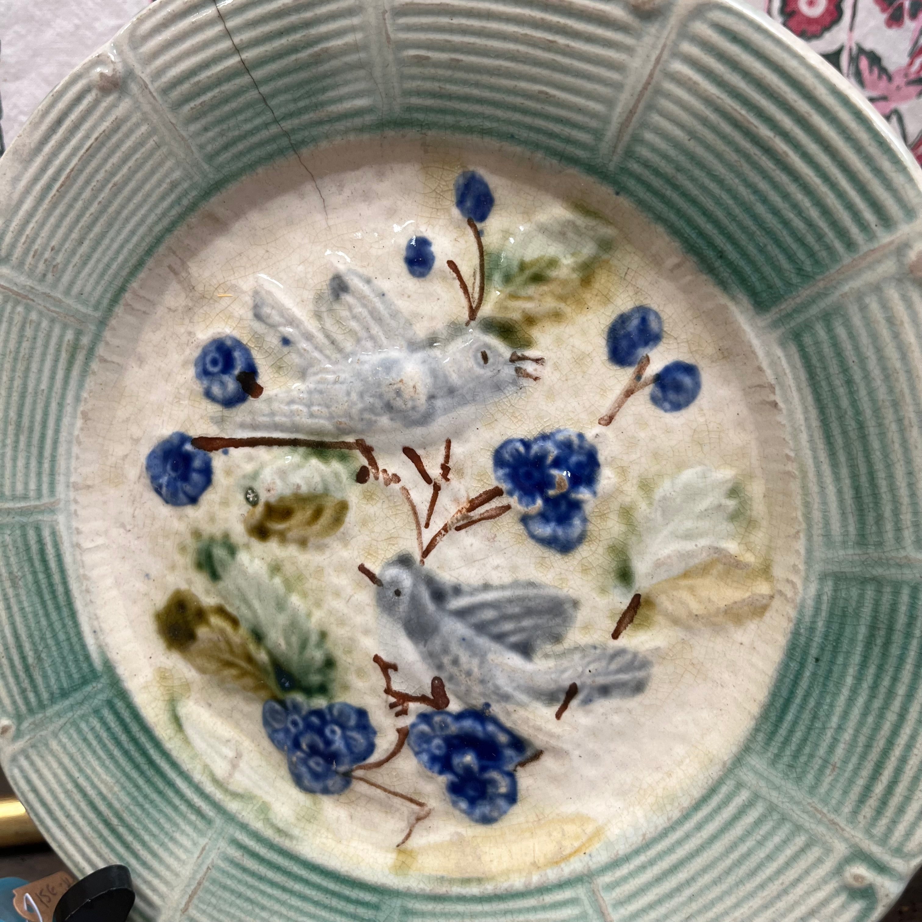 Assiette ancienne en barbotine ornée d’un décor d’oiseaux et de fleurs en relief